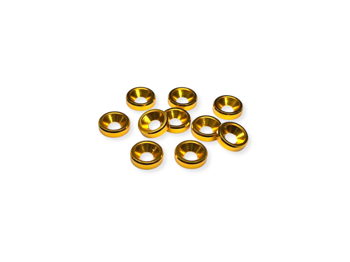 Close-up of 10 gold anodized aluminum countersink washers for M3 screws, arranged on a white background.