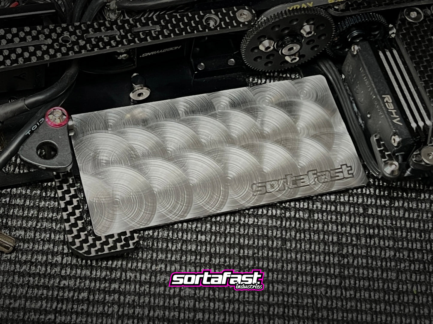 Engine-turned Sortafast stainless shorty battery weight plate mounted in RC chassis.